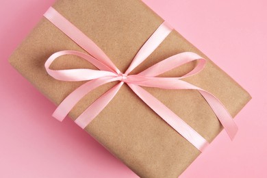 Beautiful gift box with bow on pink background, top view