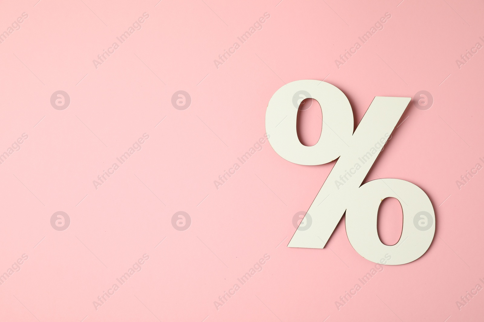 Photo of White percent sign on pink background, top view. Space for text