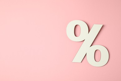 Photo of White percent sign on pink background, top view. Space for text