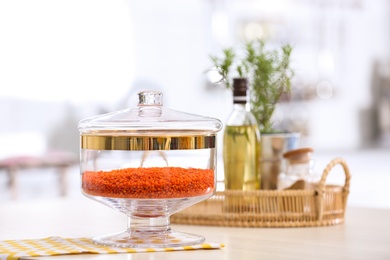 Photo of Red lentil on wooden table in modern kitchen
