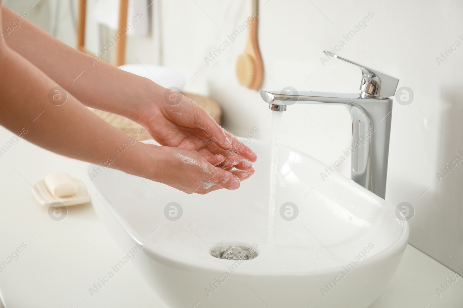 Photo of Woman washing hands indoors, closeup. Bathroom interior