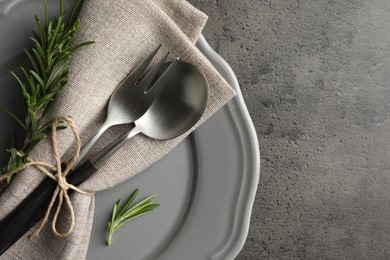 Photo of Stylish setting with cutlery and napkin on black table, top view. Space for text