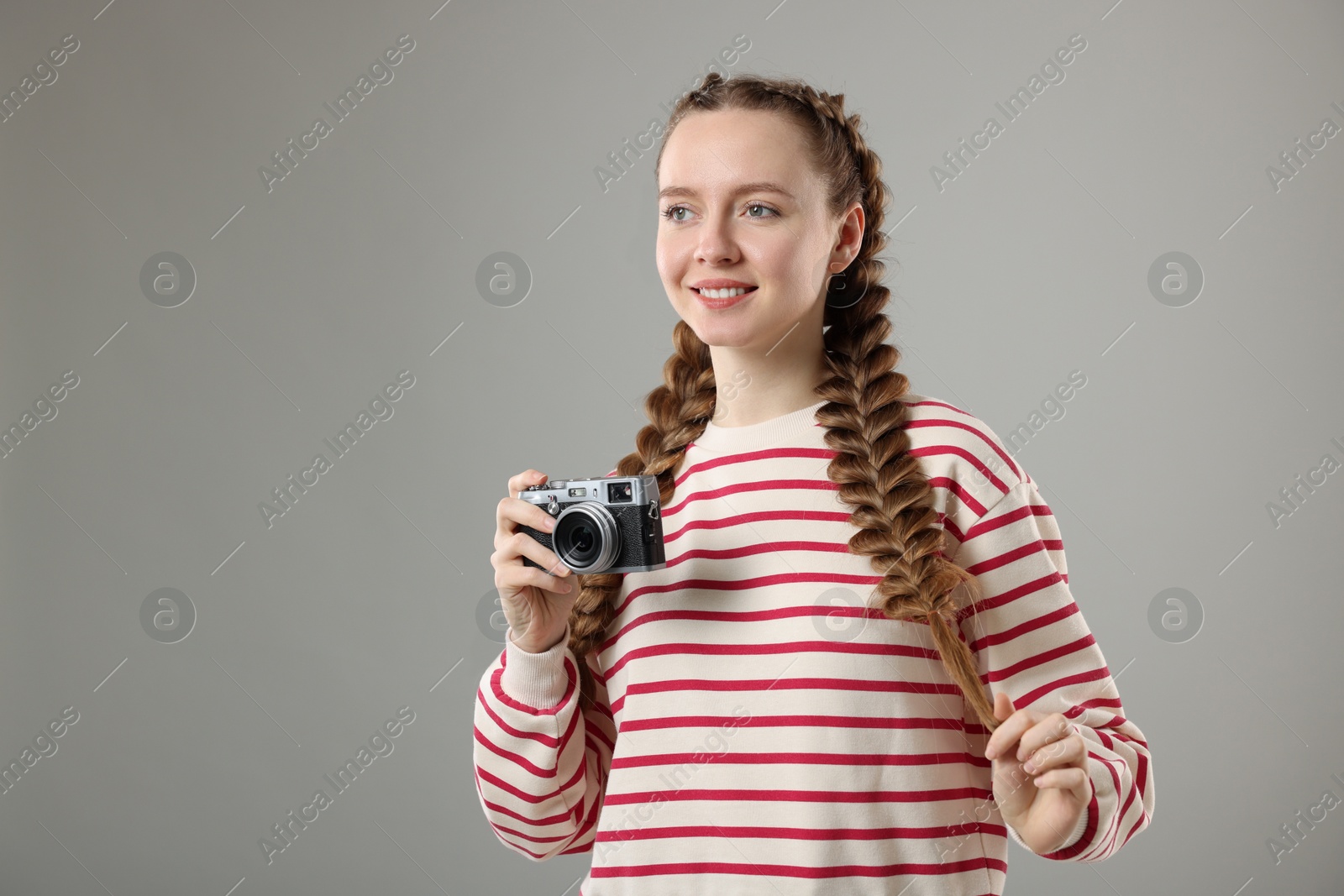 Photo of Woman with braided hair taking photo on grey background, space for text