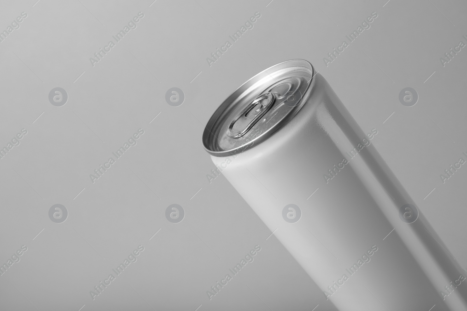 Photo of White can of energy drink on light grey background, closeup. Space for text