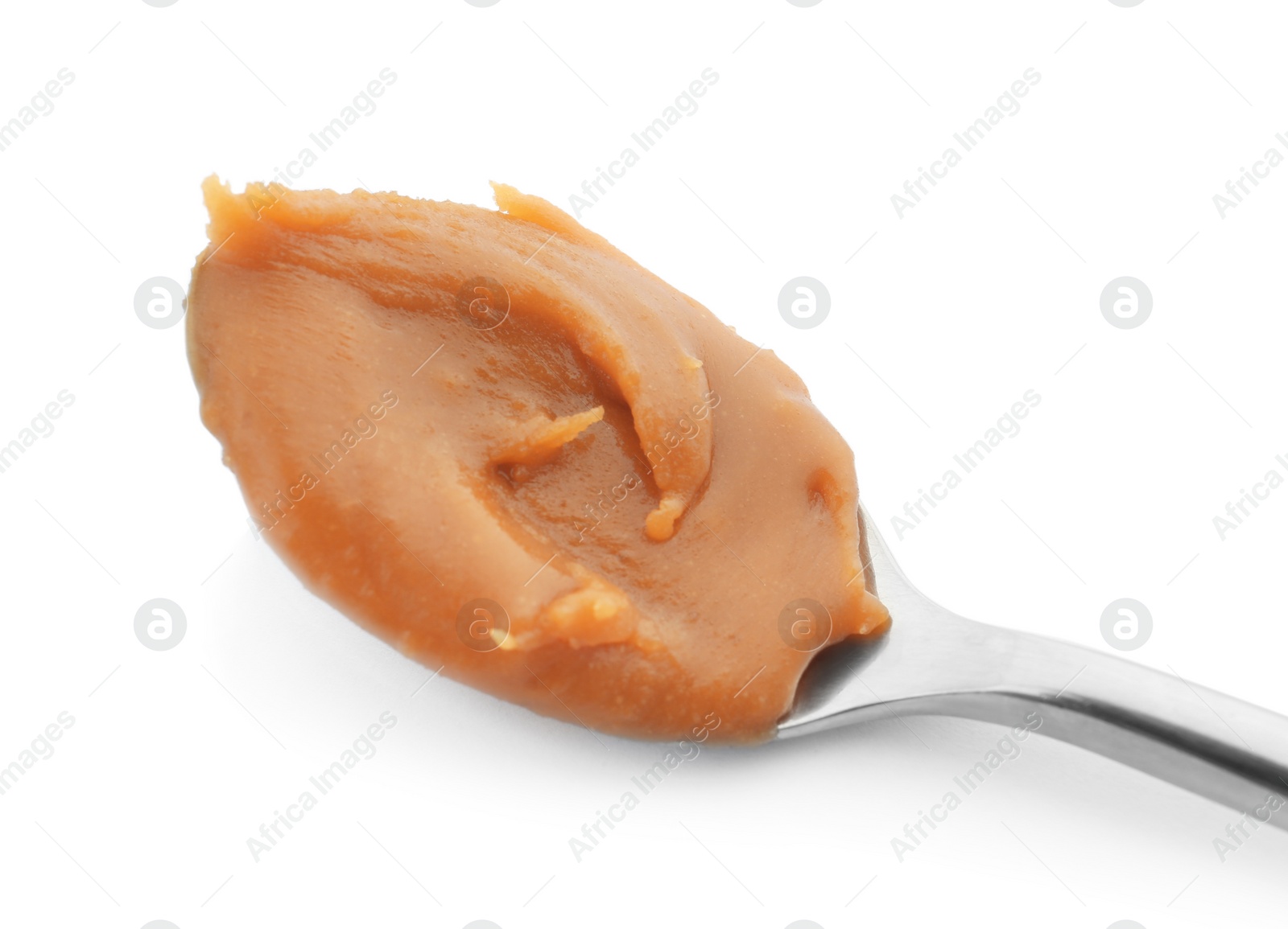 Photo of Spoon with delicious caramel on white background