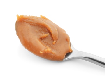 Photo of Spoon with delicious caramel on white background