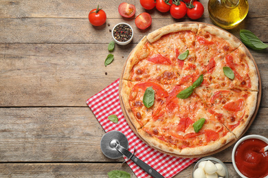 Photo of Delicious pizza Margherita and ingredients on wooden table, flat lay. Space for text