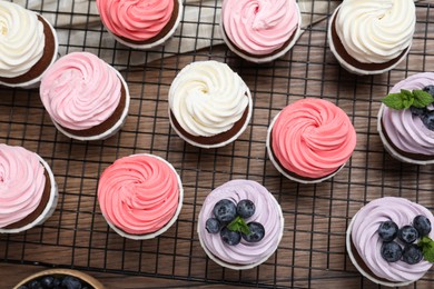 Tasty sweet cupcakes on wooden table, flat lay