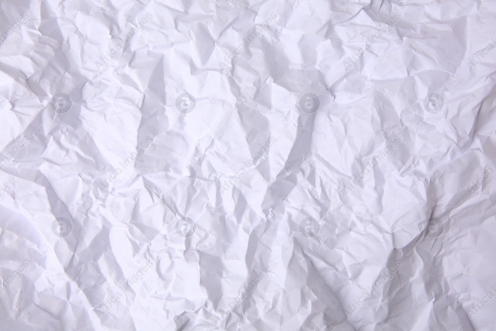 Photo of Sheet of crumpled paper white as background, top view