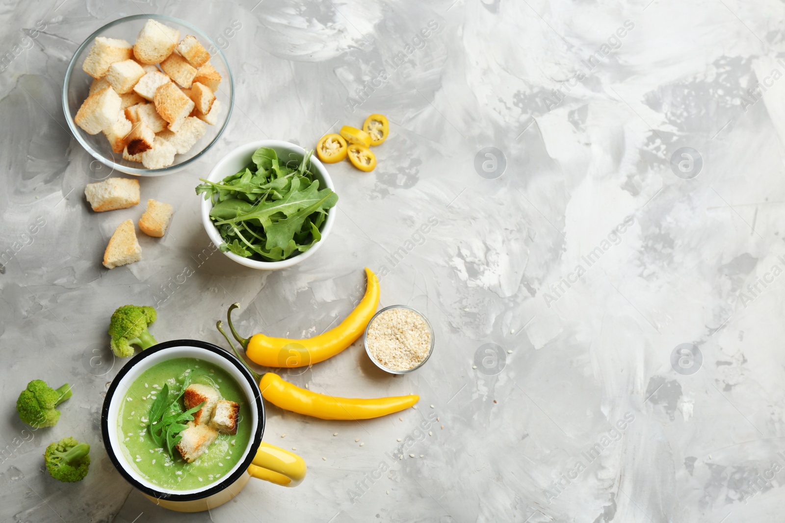 Photo of Flat lay composition with broccoli cream soup on grey table, space for text