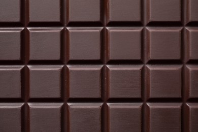 Photo of Delicious dark chocolate bar as background, top view
