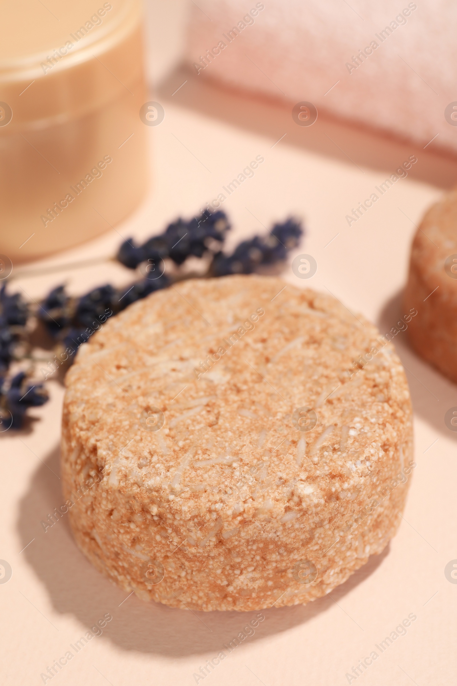 Photo of Solid shampoo bar and lavender on pink background, closeup. Hair care