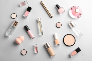 Photo of Flat lay composition with bottles of perfume and cosmetics on grey background