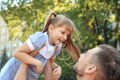 Photo of Father having fun with his cute child in green park on sunny day. Happy family