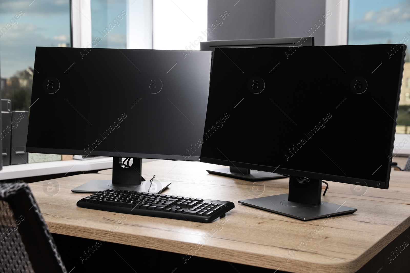 Photo of Modern interior. Workplace with multi-monitor on wooden desk in office, space for text
