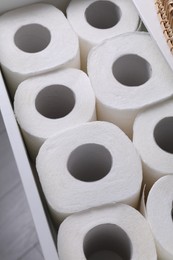 Photo of Many toilet paper rolls in white drawer indoors, above view