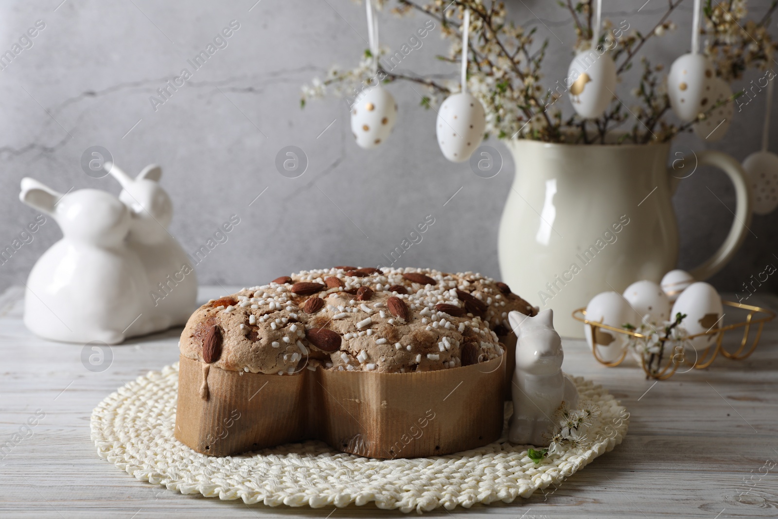 Photo of Delicious Italian Easter dove cake (Colomba di Pasqua) and festive decor on white wooden table