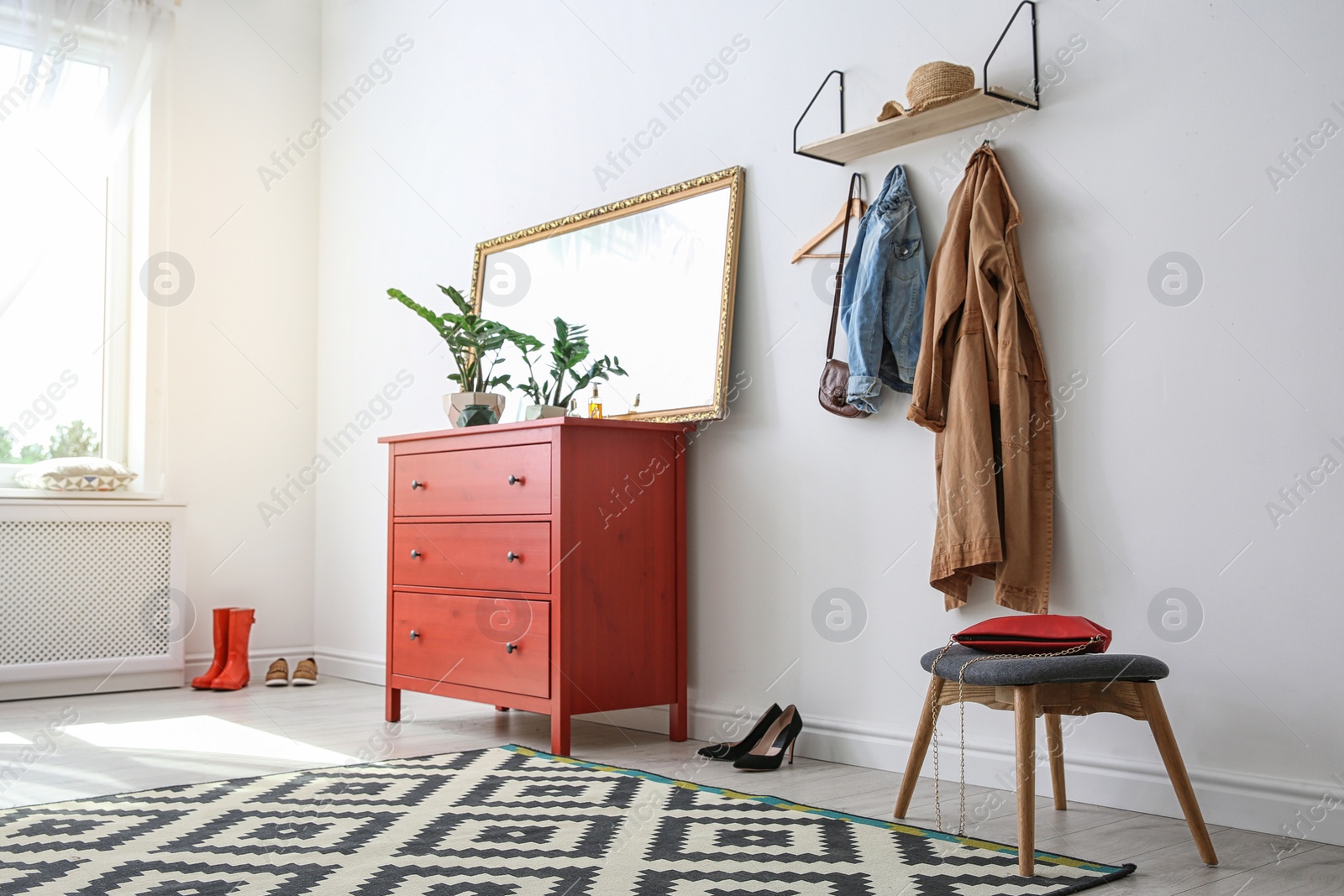 Photo of Stylish hallway interior with mirror and chest of drawers