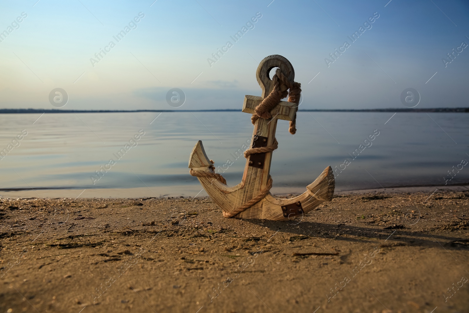 Photo of Wooden anchor on river shore near water