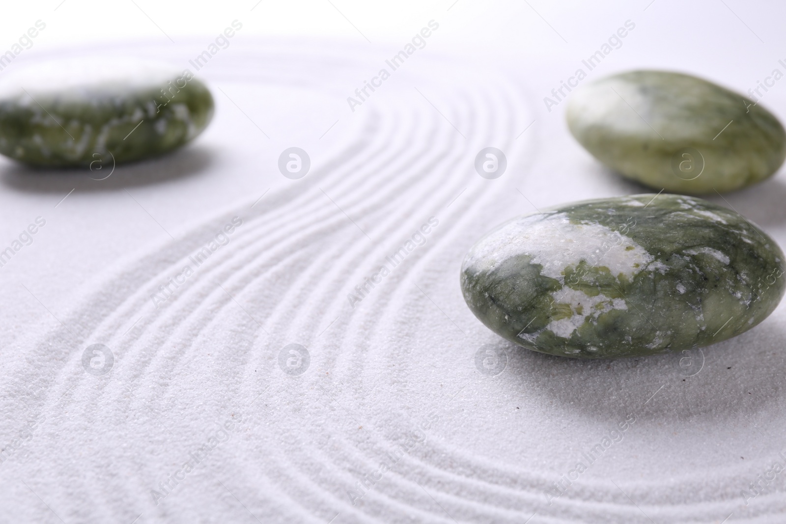 Photo of Stones on sand with pattern, space for text. Zen concept