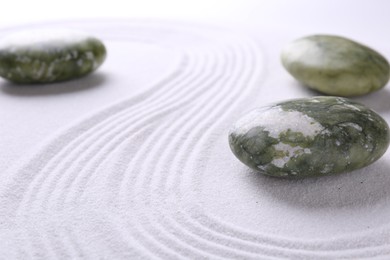 Photo of Stones on sand with pattern, space for text. Zen concept