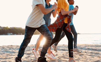 Group of children running on beach. Summer camp