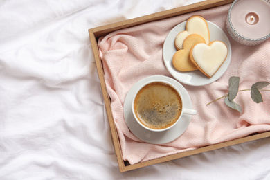 Photo of Aromatic coffee and cookies on bed, flat lay. Romantic breakfast