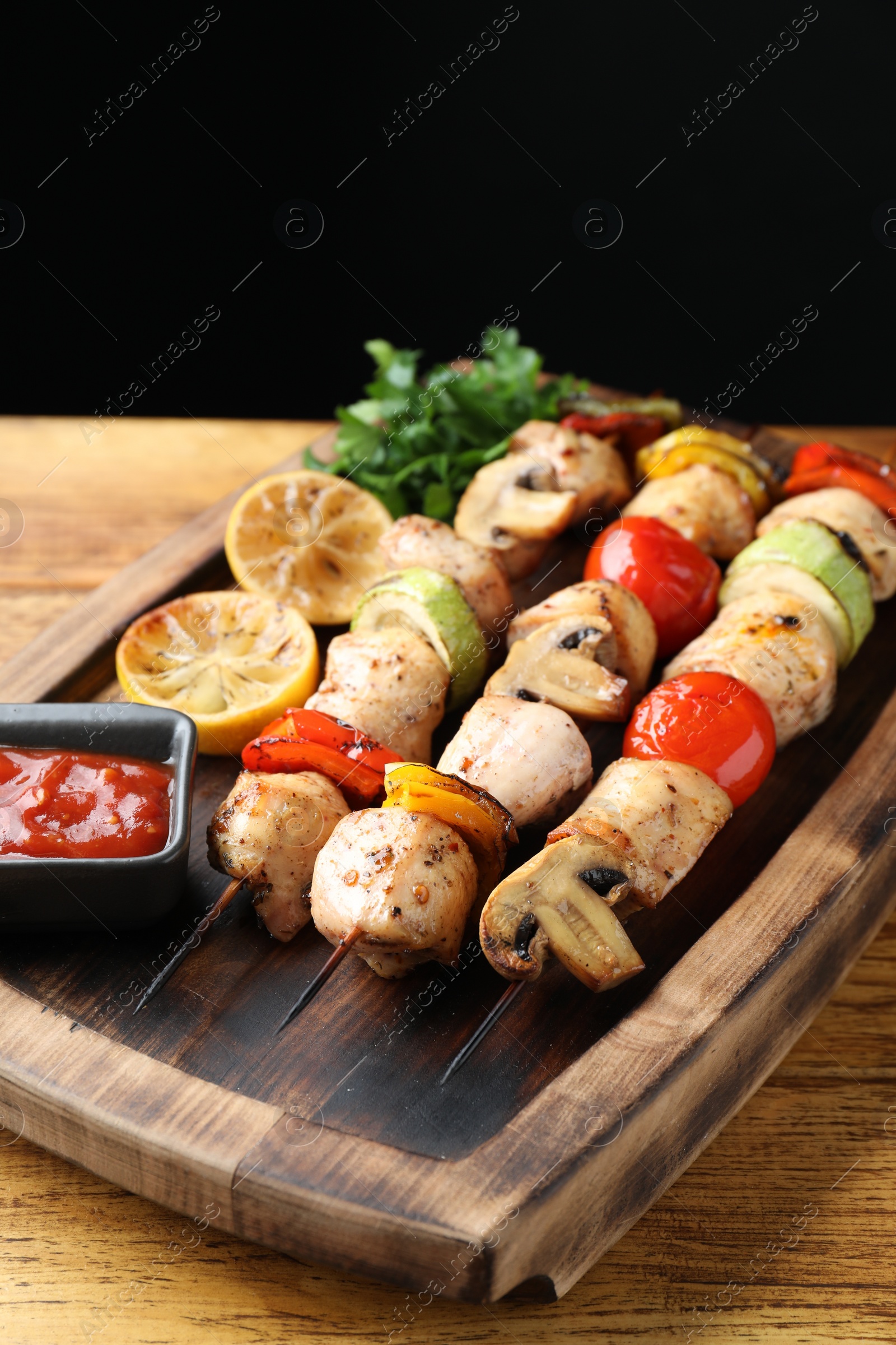 Photo of Delicious shish kebabs with grilled vegetables served on wooden table