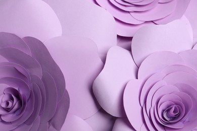 Photo of Beautiful violet flowers made of paper as background, closeup