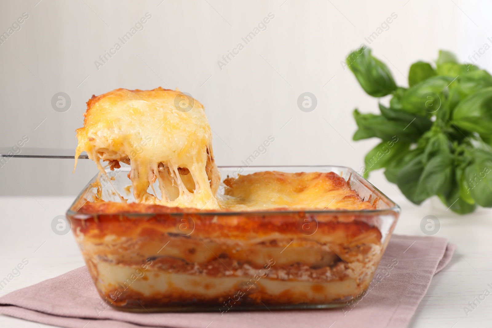 Photo of Delicious lasagna in baking dish on white table