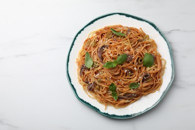 Photo of Delicious pasta with anchovies, tomato sauce and basil on white marble table, top view. Space for text