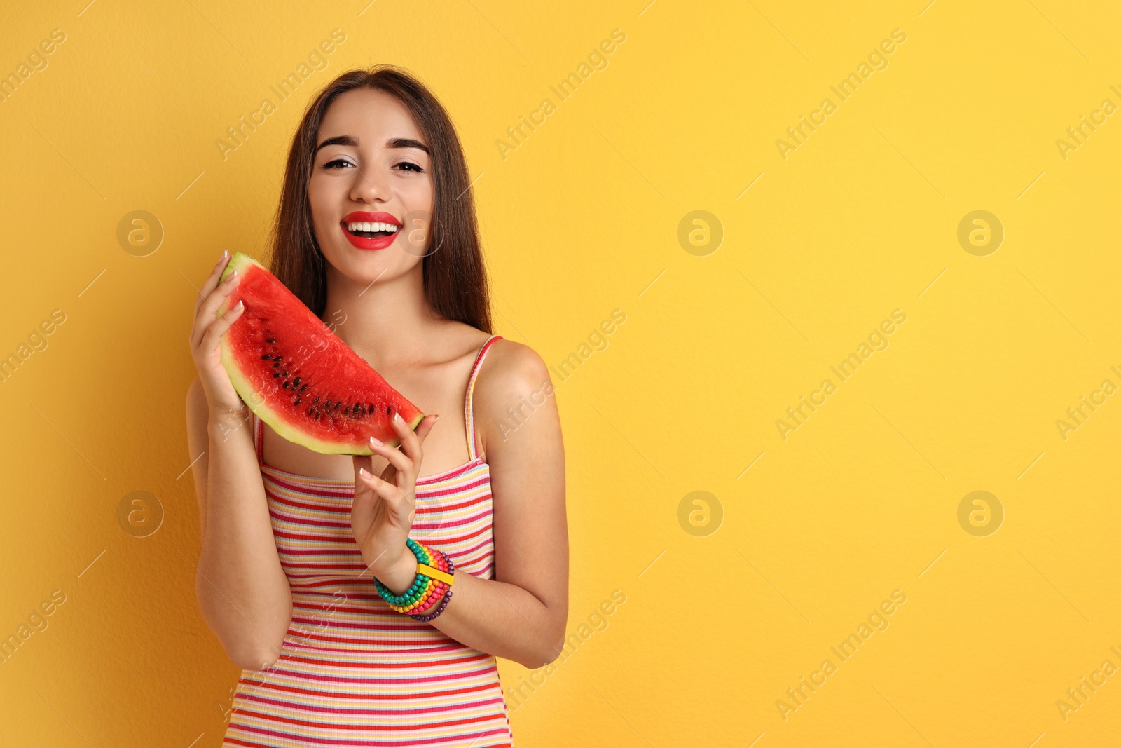 Photo of Beautiful young woman posing with watermelon on color background