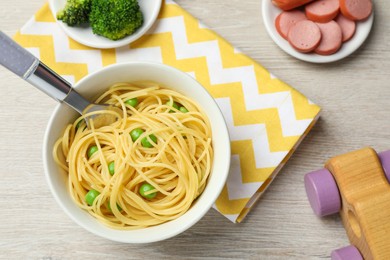 Photo of Flat lay composition with bowl of tasty pasta on wooden table