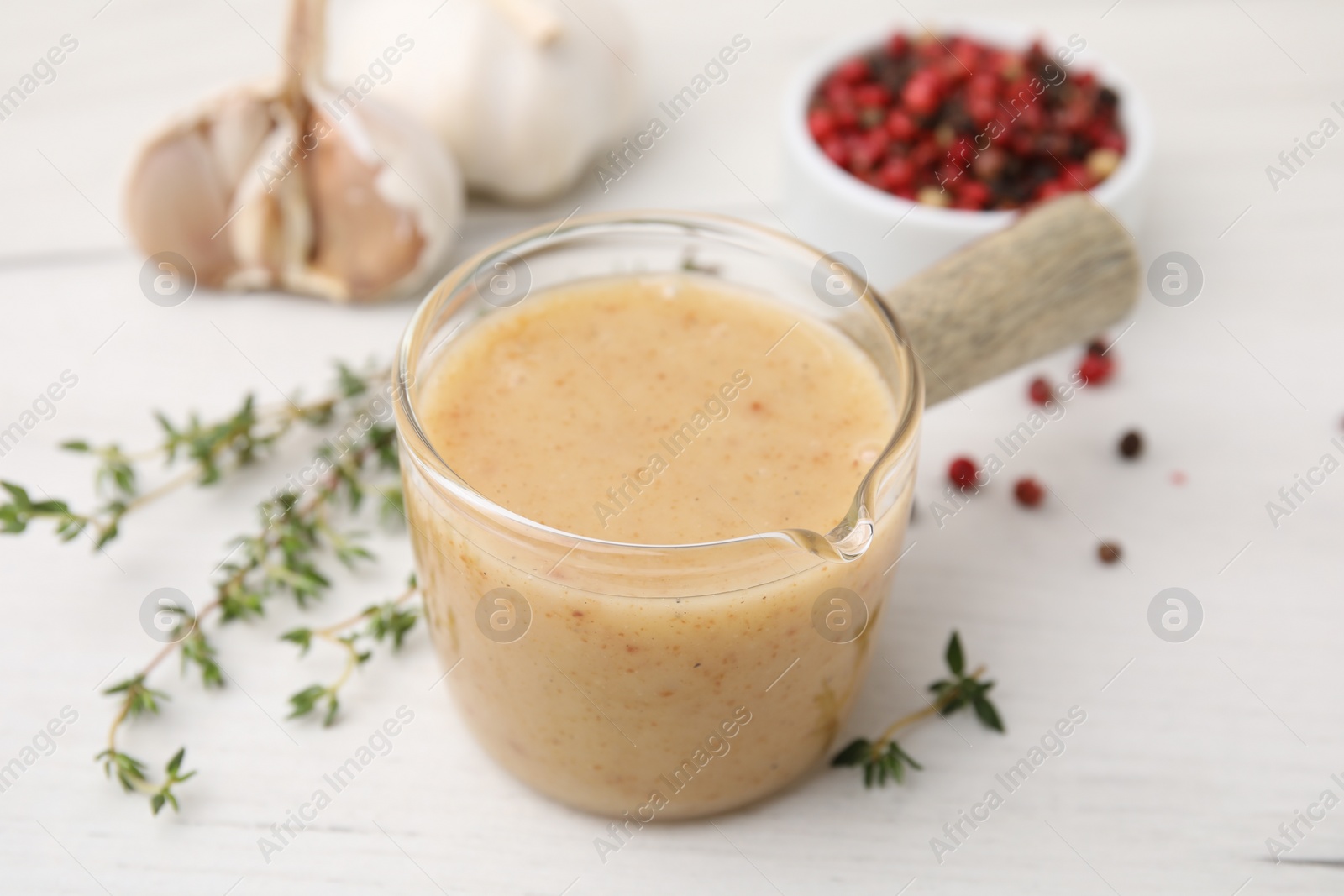 Photo of Delicious turkey gravy and thyme on white table, closeup