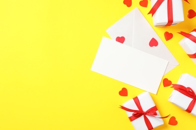 Photo of Flat lay composition with blank card on yellow background, space for text. Valentine's Day celebration