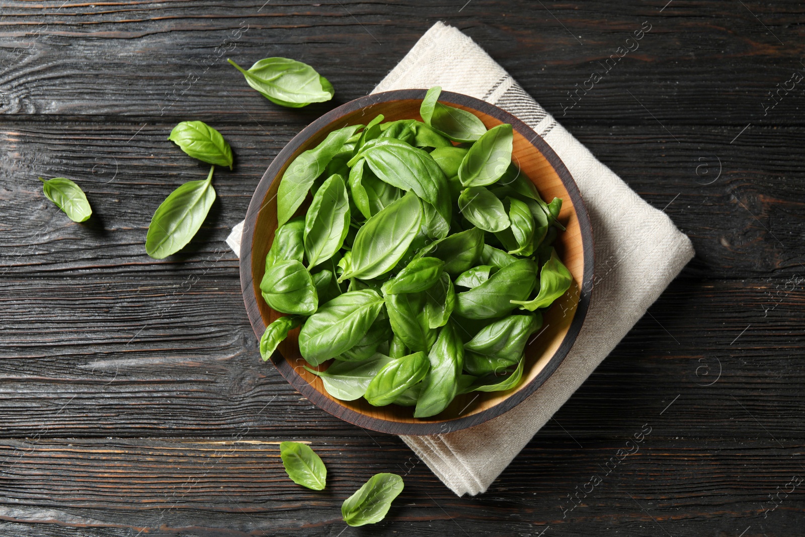 Photo of Fresh green basil on black wooden table, flat lay