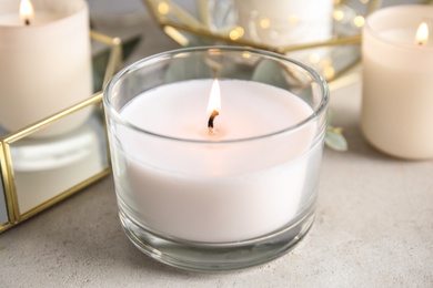 Photo of Burning aromatic candle in holder on table