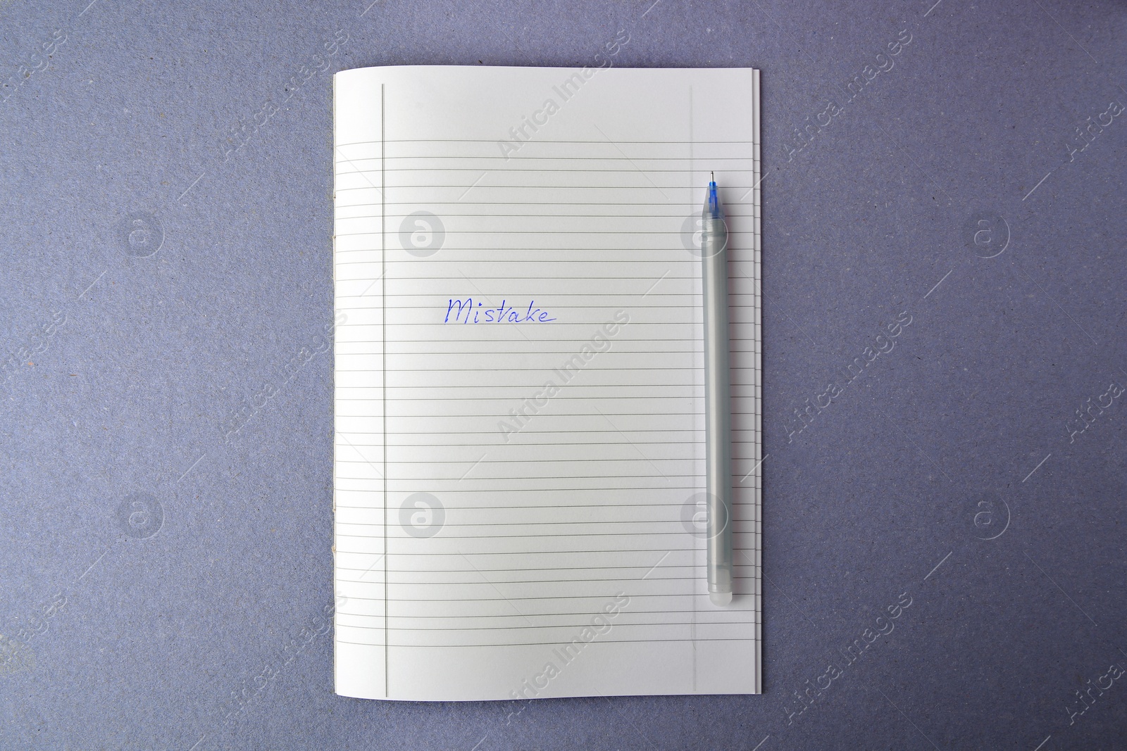 Photo of Word Mistake written with erasable pen in copybook on grey background, top view