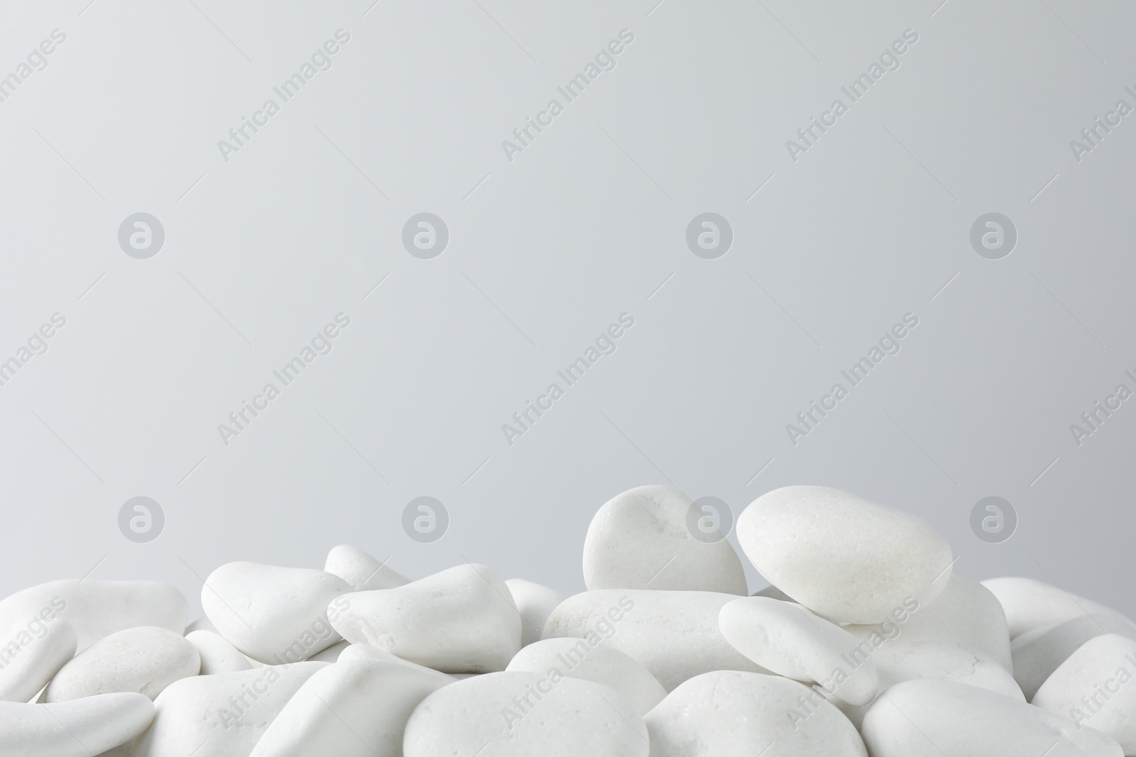 Photo of Presentation for product. White pebbles on light background. Space for text