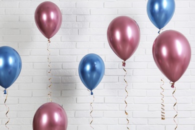 Photo of Bright colorful balloons near brick wall. Party time