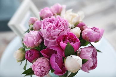 Photo of Bouquet of beautiful peonies on table in room, closeup