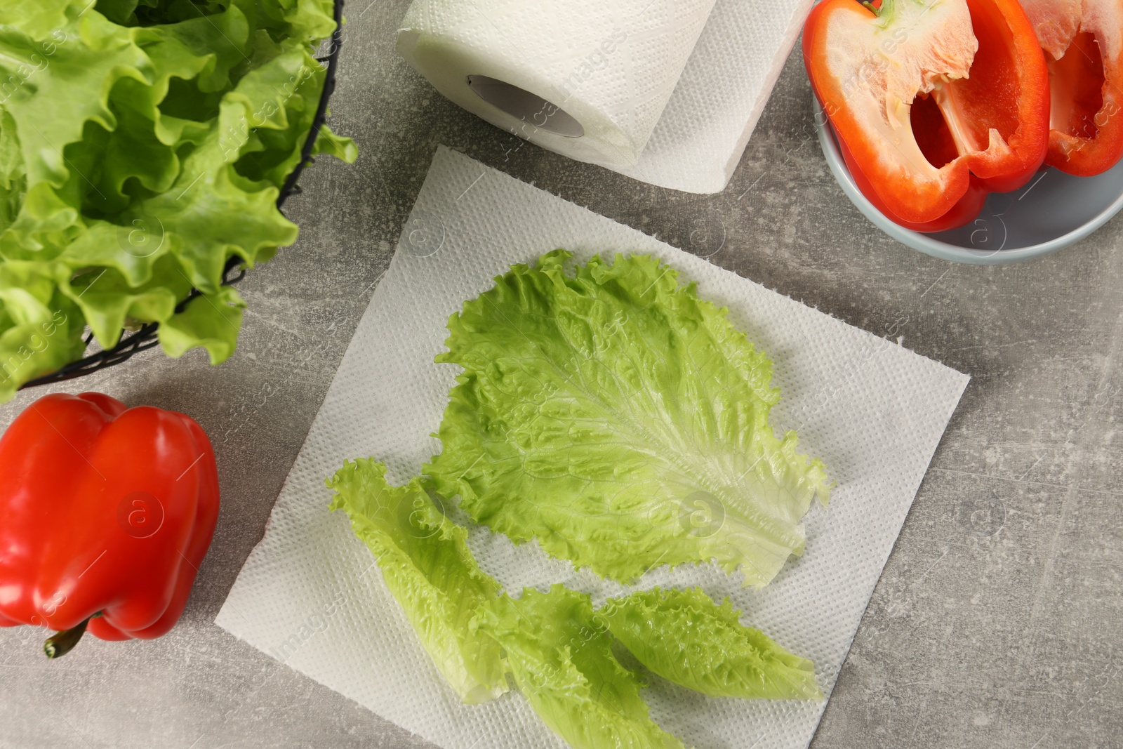 Photo of Paper towels, lettuce and bell peppers on grey table, flat lay