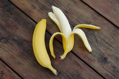 Photo of Delicious yellow bananas on wooden table, flat lay