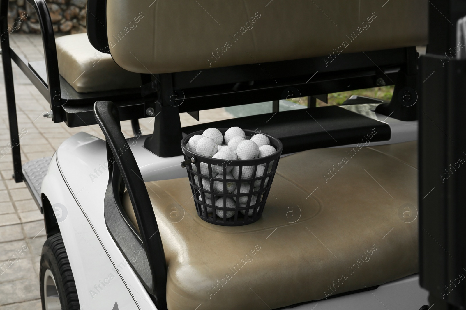 Photo of Green basket with golf balls on car seat outdoors