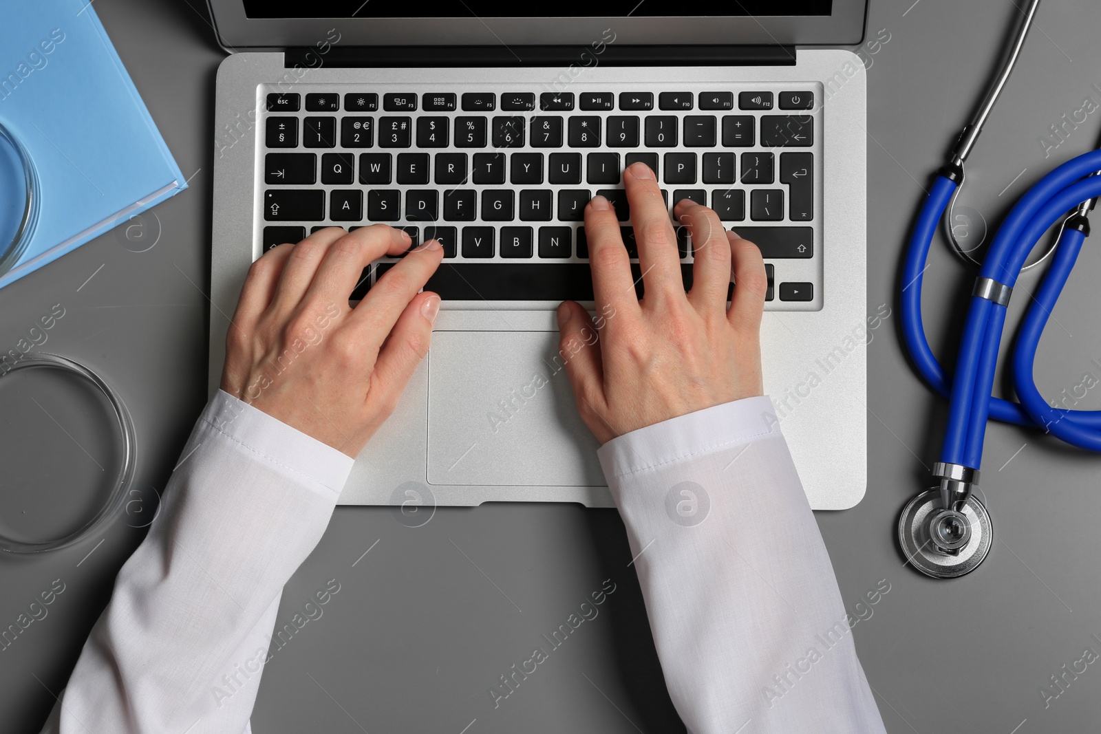 Photo of Student with modern laptop and medical stuff at table, top view