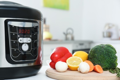 Modern multi cooker and products on kitchen table