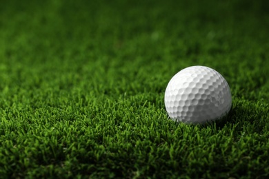 Photo of Golf ball on artificial grass, space for text