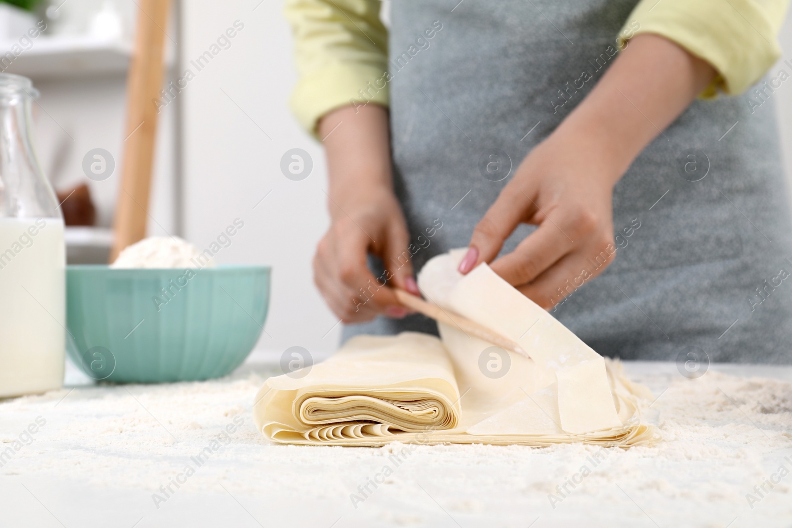 Photo of Making tasty baklava. Woman with dough at table, closeup