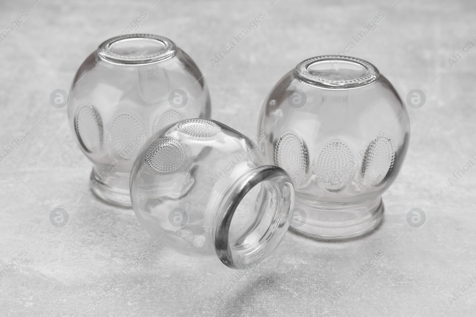 Photo of Glass cups on grey table, closeup. Cupping therapy