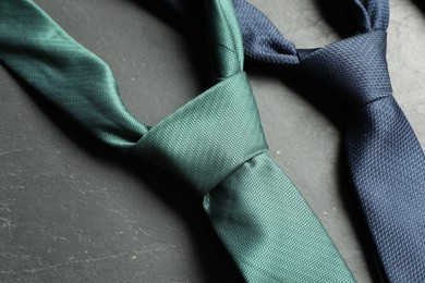 Two neckties on grey textured table, closeup